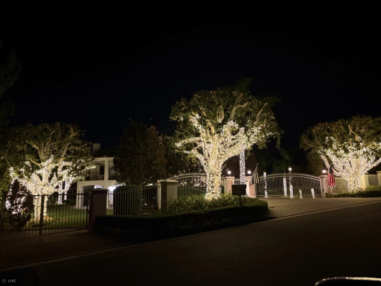 Gated estate with light-wrapped specimen trees